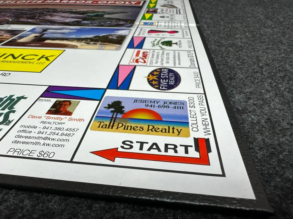 Close-up of the START corner of a Charlotte Harbor-Opoly board showing local business property spaces