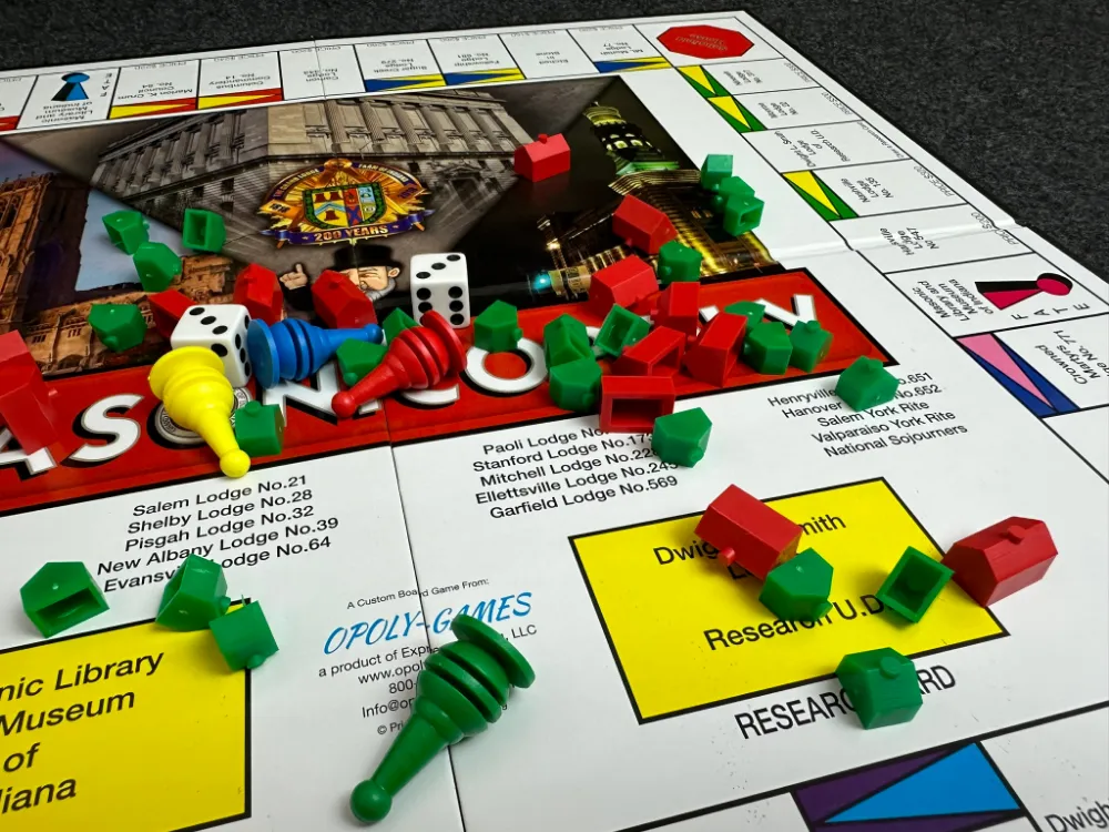 A finished Masonicopoly board mid-game with houses, hotels, and dice